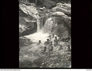 NEW GUINEA. C. 1943. A GROUP OF RAAF AIRMEN ENJOYING A SWIM IN A MOUNTAIN STREAM IN THE JUNGLE