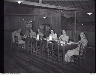 MILNE BAY, PAPUA. OFFICERS AT THE MEAL TABLE IN THE WARDROOM OF HMAS LADAVA. (NAVAL HISTORICAL COLLECTION)