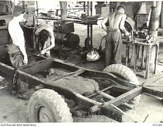 PORT MORESBY, NEW GUINEA. 1944-04-10. VX132018 CRAFTSMAN W. COLLONGS (1), WITH VX57565 CORPORAL F.S. REGAN (2), WELDING A TRUCK CHASSIS AT THE 11TH ADVANCED WORKSHOP, AUSTRALIAN ELECTRICAL AND ..