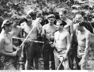 BOUGAINVILLE, 1945-06-07. TROOPS OF 2/8 COMMANDO SQUADRON ADMIRING JAPANESE SWORDS CAPTURED BY THEIR MATES IN A RAID ON A PARTY OF JAPANESE TROOPS MOVING ALONG THE BUIN ROAD. IDENTIFIED PERSONNEL ..