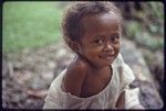 Mogiovyeka's daughter, Imala, smiles, she wears turtle shell earrings