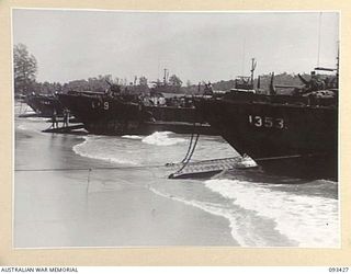 AITAPE BEACH HEAD, NEW GUINEA. 1945-06-19. LANDING CRAFT TANKS LINED UP ON THE BEACH WHILE BEING LOADED BY MEMBERS OF 7 DOCKS OPERATING COMPANY, ROYAL AUSTRALIAN ENGINEERS, WITH STORES AND SUPPLIES ..