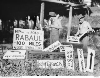 SAMPUN, NEW BRITAIN. 1945-01-15. T24470 SAPPER L.K. SELF (1) AND T20941 LANCE CORPORAL K.R. BAKER (2) OF THE 12TH FIELD COMPANY, PAINTING ROAD SIGNS TO BE ERECTED ALONG THE COAST ROAD BETWEEN ..