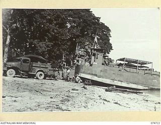 MADANG, NEW GUINEA. 1944. BARGES AND "DUKWS" DRAWN UP ON THE BEACH FOR REPAIR AND OVERHAUL AT THE 593RD UNITED STATES BARGE COMPANY REPAIR WORKSHOPS