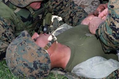 US Marine Corps (USMC) Lance Corporal (LCPL) Franco, Golf Company, 2nd Battalion (BN) 3rd Marine Regiment, pretends to pass out from complications from a sucking chest wound during Squad Competitions in preparation for the Super Squad Competition
