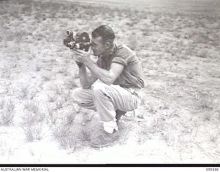 TOROKINA, BOUGAINVILLE, 1945-12-05. DRIVER T. W. CLIFFORD, USING HIS MOVIE CAMERA DURING THE RUNNING OF EVENTS AT THE 3 DIVISION AMENITIES ATHLETIC CARNIVAL HELD AT GLOUCESTER OVAL