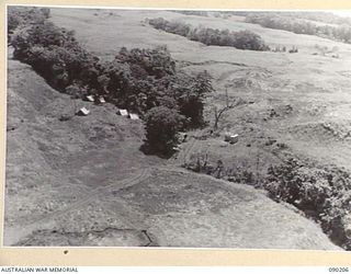 GOODENOUGH ISLAND, NEW GUINEA. 1942-10. TENTS AND WHEEL MARKS WITH NEITHER MEN OR VEHICLES WERE PART OF THE BLUFF AND DECEPTION PRACTICED BY A SMALL GROUP OF AUSTRALIANS WHO SEIZED THE ISLAND, AND ..