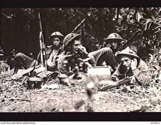 FINSCHHAFEN, NEW GUINEA. 1943-10-02. TROOPS OF THE 24TH BATTERY, 2/12TH AUSTRALIAN FIELD REGIMENT, USING A JAPANESE TELEPHONE UNIT WHICH WAS CAPTURED EARLY IN THE CAMPAIGN. LEFT TO RIGHT:- SX12543 ..