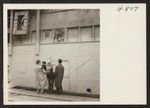 A group of Los Angeles Nisei bid farewell to old friends aboard the SS Shawnee, Army Troop Transport, detailed to return persons of Japanese ancestry, evacuated from Hawaii during the war, to their former homes. Photographer: Mace, Charles E. Los Angeles, California