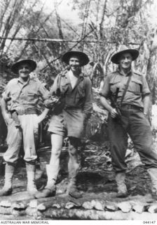 War photographer Damien Parer photographed with two diggers. This picture was taken shortly after Parer had distinguished himself by helping to carry a badly wounded soldier to safety during an ..