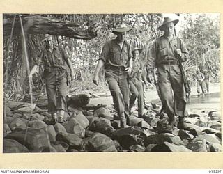 1943-07-28. NEW GUINEA. AN AUSTRALIAN PATROL PICKS ITS WAY ALONG THE ROCKS AT NASSAU BAY. AUSTRALIANS AND AMERICANS CLEARED THE BAY OF THE JAPS AND FINALLY DROVE THE ENEMY OUT OF MUBO TO THE NORTH ..