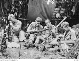 1942-10-19. VETERAN A.I.F. MEN OF A UNIT THAT FOUGHT IN THE WESTERN DESERT AND SYRIA ARE NOW IN ACTION AGAIN IN NEW GUINEA. THIS PICTURE TAKEN IN THE KOKODA AREA, SHOWS A GROUP OF THEM CLEANING ..