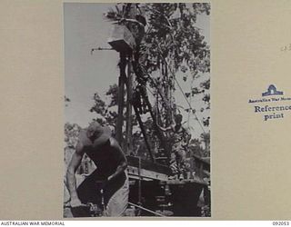 BOUGAINVILLE. 1945-05-16. SAPPERS OF 15 FIELD COMPANY, ROYAL AUSTRALIAN ENGINEERS, CONSTRUCT A TIMBER BRIDGE OVER SINDOU CREEK, USING AN IMPROVISED PILE DRIVER MOUNTED ON A 3 TON WINCH TRUCK. ..