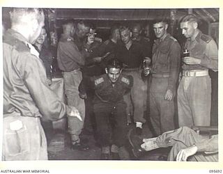 TOKO, BOUGAINVILLE. 1945-08-28. STAFF OFFICERS OF HEADQUARTERS 3 DIVISION INDULGING IN COMPETITIVE PHYSICAL FEATS AFTER A DINNER HELD TO CELEBRATE VICTORY OVER JAPAN. THE DINNER WAS ATTENDED BY ..
