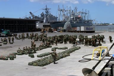 US Marine Corps (USMC) personnel from the 3rd Battalion 3rd Marine Regiment (MAR REGT) I Company (CO) and Combat Service Support Detachment 77 (CSSD-77) wait on shore to embark the US Navy (USN) Amphibious Assault Ship USS TARAWA (LHA 1) at pier K-10, Pearl Harbor, Hawaii (HI). The TARAWA is participating in the amphibious exercise, Rim of the Pacific (RIMPAC) 2004