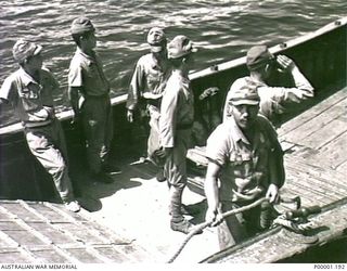 THE SOLOMON ISLANDS, 1945-08-20. MEMBERS OF A JAPANESE BARGE CREW ALONGSIDE HMAS LITHGOW OFF MOILA POINT. THE BARGE HAD DELIVERED JAPANESE OFFICERS FOR SURRENDER DISCUSSIONS. (RNZAF OFFICIAL ..