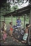 Children watch Edwin Hutchins with motorcycle