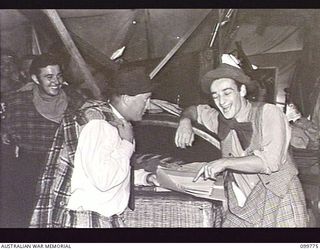 TOROKINA, BOUGAINVILLE, 1945-11-03. SERGEANT J. WILSON (1) AND PRIVATE E. HEYLEN (2), COMEDIANS OF THE KOOKAROOS CONCERT PARTY, AUSTRALIAN ARMY AMENITIES SERVICE, REHEARSING THEIR JOKES BEFORE ..