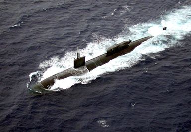 Aerial port bow view of the US Navy (USN) LOS ANGELES CLASS; Attack Submarine, USS GREENEVILLE (SSN 772), underway in the Pacific Ocean while conducting Advanced Seal Delivery System (ASDS) sea testing, off the coast of Pearl Harbor, Hawaii. ASDS is a 65-foot, mini-submarine, which rides attached to the top of a much larger Los Angeles Class submarine