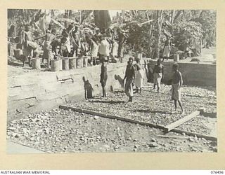 LAE, NEW GUINEA. 1944-10-18. NATIVES BUSILY ENGAGED IN MAKING A SWIMMING POOL AT THE LAE NATIVE LABOUR COMPOUND, AUSTRALIAN NEW GUINEA ADMINISTRATIVE UNIT, LAE BASE SUB AREA. THIS COMPOUND, HOUSING ..