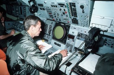 Lieutenant Commander (LTC) Cullen sits at the tactical coordinator's station in the P-3 Orion weapons system trainer (WST)