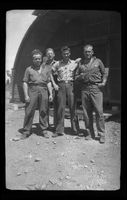 [Servicemen in front of Quonset hut]