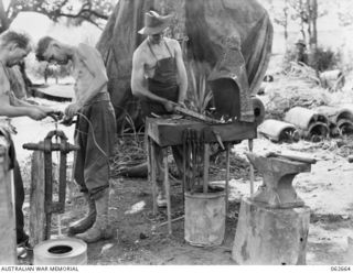 Fitters of the 53rd Australian Field Park Company, Royal Australian Engineers, 7th Australian Division working in the unit blacksmith shop NX21178 Sapper (Spr) F Johnson (left) and QX16907 Spr E ..