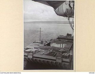 RABAUL, NEW BRITAIN, 1945-11-30. A 300-TON LIGHTER USED FOR BRINGING CARGO ASHORE FROM SHIPS, LYING ALONGSIDE THE SS CHARON IN SIMPSON HARBOUR