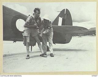 WARD'S DROME, PORT MORESBY, PAPUA, 1944-02. SERGEANT KENNETH MAXWELL DOUGLAS, ROYAL AUSTRALIAN AIR FORCE (1), BEING ASSISTED INTO HIS PARACHUTE BY PRIVATE FIRST CLASS VANCE JACKSON OF PAYETTVILLE, ..