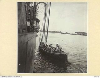 MADANG, NEW GUINEA. 1944-11-20. MEMBERS OF THE CREW OF THE ROYAL AUSTRALIAN NAVY VESSEL, HMAS "BENDIGO" HAULING A WHALEBOAT ABOARD WHILE THE VESSEL IS ANCHORED IN THE HARBOUR