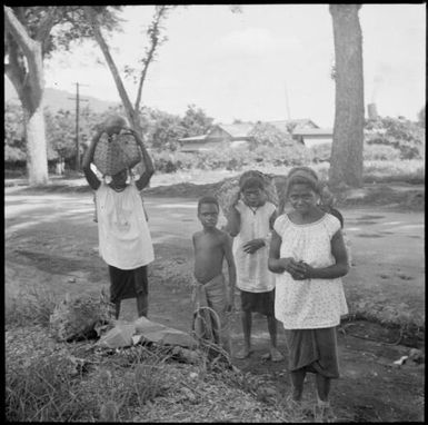 View along Malaguna Road of women carrying produce to the Boong, native markets, Rabaul, New Guinea, ca. 1935 / Sarah Chinnery