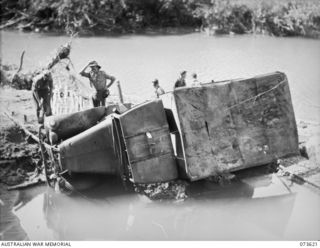 MARUKINAM RIVER, NEW GUINEA. 1944-05-28. TROOPS OF THE 35TH INFANTRY BATTALION EXAMINE AN ABANDONED JAPANESE TRUCK DISCOVERED IN A BOMB HOLE ON THE BANK OF THE RIVER, DURING THE ADVANCE UP THE ..