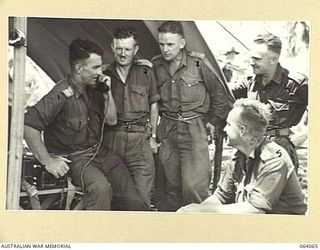 NAMBARIWA, NEW GUINEA. 1944-01-21. OFFICERS OF THE 4TH INFANTRY BATTALION DISCUSSING PLANS OF OPERATIONS AT THEIR COMMAND POST. SHOWN ARE:- NX112661 LIEUTENANT COLONEL P.W. CROSKY, COMMANDING ..