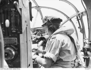 416026 Flying Officer Alan Keith Sigley Lorimer, 100 Squadron RAAF, of Kingaroy, Qld, in the navigator's seat in Beaufort Bomber Ag-633 QHZ, while on a mission over nort east New Guinea. The crew ..