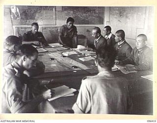 CAPE WOM, NEW GUINEA, 1945-09-13. AT A CONFERENCE BETWEEN STAFF OFFICERS OF 6 DIVISION, AND JAPANESE STAFF OFFICERS OF 18 JAPANESE ARMY, LIEUTENANT-COLONEL J. BISHOP GENERAL STAFF OFFICER I, WHO ..