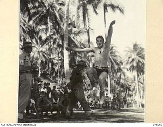 MILILAT, NEW GUINEA. 1944-09-03. NX102131 STAFF SERGEANT G.L. RICH, COMPETING IN THE BROAD JUMP EVENT AT THE SPORTS MEETING ORGANISED BY THE 5TH DIVISION TO COMMEMORATE THE 5TH ANNIVERSARY OF THE ..