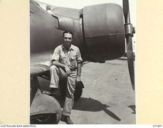 LAE, NEW GUINEA. 1944-03-30. LIEUTENANT THOMPSON, UNITED STATES ARMY AIR FORCE, BASE OPERATIONS, STANDING BESIDE HIS AIRCRAFT