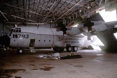 A Fleet Logistics Support Squadron 50 (VRC-50) C-130 Hercules aircraft is trapped beneath a partially collapsed hangar in the aftermath of Typhoon Omar which struck the area on August 29th, causing severe damage to Andersen; Naval Station, Guam; and the surrounding area