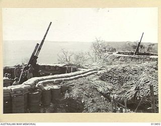 1942-11-06. SHOT OF AN AUSTRALIAN ANTI-AIRCRAFT BATTERY SOMEWHERE IN NEW GUINEA. THIS BATTERY IS MANNED ENTIRELY BY VICTORIANS USING GUNS MANUFACTURED IN A VICTORIAN FACTORY AND THEIR BAG OF ENEMY ..