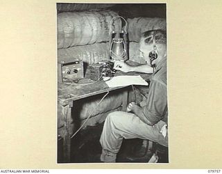 AITAPE, NEW GUINEA. 1945-03-16. A FULLERPHONE MK 4 (SPECIAL AUSTRALIAN PATTERN) SET USED IN LONG RANGE WORK FROM AN OPEN DUGOUT, OPERATED BY A MEMBER OF HEADQUARTERS 6TH DIVISION SIGNALS