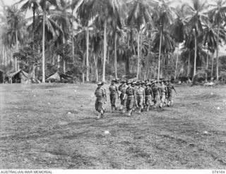 SIAR, NEW GUINEA. 1944-06-22. PERSONNEL OF COMPANY HEADQUARTERS, B COMPANY, 57/60TH INFANTRY BATTALION, MARCHING OFF THE UNIT PARADE GROUND. IDENTIFIED PERSONNEL ARE:- VX3964 CAPTAIN F.D. CLARKE ..