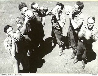 MILNE BAY, NEW GUINEA. 1944-04-06. PERSONNEL AT 53RD DEPUTY COMMANDER, ROYAL AUSTRALIAN ENGINEERS, DRINKING COCONUT MILK, A FAVOURITE BEVERAGE WITH TROOPS IN THE AREA. IDENTIFIED PERSONNEL ARE:- ..