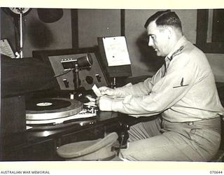 PORT MORESBY, PAPUA, 1944-02-26. THE GENERAL MANAGER, AUSTRALIAN BROADCASTING COMMISSION, LIEUTENANT COLONEL C.J.A. MOSES, DELIVERING HIS ADDRESS FROM NO.1 STUDIO, "9PA", DURING THE STATION'S ..