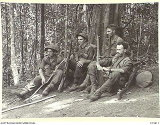 1942-10-09. FOUR MEN OF THE NEW GUINEA FORCE RESTING AFTER A JUNGLE PATROL. THEY ARE, PRIVATES B. BERWICK, J. SCHLECHT, R.G. WRIGHT AND J.A. INNES. (NEGATIVE BY BOTTOMLEY)