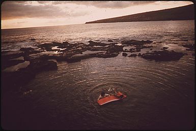 HAWAIIAN CHILDREN SWIM AT DUSK IN MANELE BAY