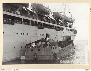 WEWAK AREA, NEW GUINEA. 1945-05-30. TROOPS WATCH OVER THE SIDE AS A 43 LANDING CRAFT COMPANY BARGE COMES ALONGSIDE THE SS TAROONA IN WEWAK HARBOUR. THE SHIP, FORMERLY OF THE INTERSTATE PASSENGER ..