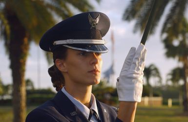 US Air Force (USAF) AIRMAN (AMN) Jennifer Kincaid, Judge Advocate (JA) office, 15th Airlift Wing (AW), Hickam Air Force Base (AFB), Hawaii (HI), and 15th AW Honor Guard member, lifts her sword during a Cordon Ceremony, conducted outside the Hickam AFB Officers Club, at the start of the 2003 Team Hickam Annual Awards Banquet