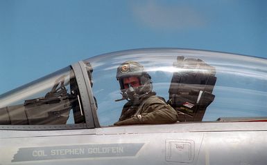 Close up view of Captain (CPT) Andy Hamann, US Air Force (USAF), F-15C Eagle aircraft pilot assigned to the 19TH Fighter Squadron as he sits on the cockpit of his aircraft after arriving at Anderson AFB, Guam in support of Exercise TANDEM THRUST '99