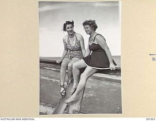 LAE, NEW GUINEA, 1945-05-18. SIGNALWOMAN O. FREEMAN (1), AND SIGNALWOMAN E.G. MILLARD (2), PERSONNEL FROM AUSTRALIAN WOMEN'S ARMY SERVICE BARRACKS, ON THE TOP DECK OF THE "MALAHANG WRECK" A ..