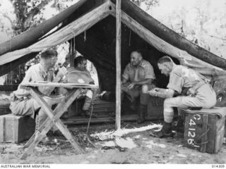 1943-02-04. NEW GUINEA. PHOTOGRAPHED IN BRIG. WOOTTEN'S TENT ON SANANANDA BEACH ARE GENERAL HERRING, GENERAL VASEY AND BRIG. WOOTTEN. (NEGATIVE BY BOTTOMLEY)